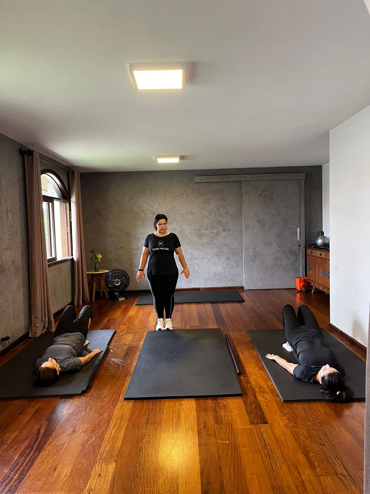 Instrutora corrigindo postura durante aula de Pilates
